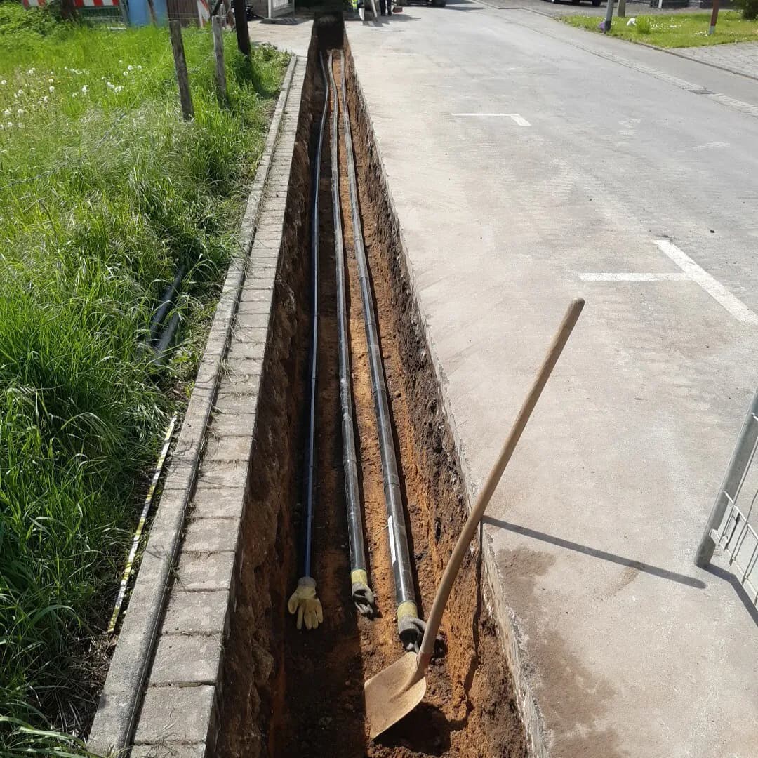 Graben im Asphalt mit Leerrohranlage